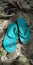 a pair of broken green flip-flops
