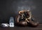 Pair of brown leather vintage boxing gloves, silicone cap and wrist bandage, wooden background