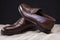 Pair of Brown Stylish Leather Penny Loafer Shoes Placed On Mesh Surface