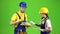 Pair of builders choose wooden boards. Green screen