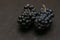 Pair of bunches of dark ripe grapes on wooden black table