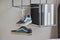 Pair of casual blue sneaker shoes hanging on book shelf