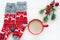 A pair of Christmas ornament red socks and a red cup of cocoa on white background