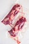 Pair of chuck roll beef steak,  vacuum packed organic meat for sous vide cooking  on white concrete  textured background, top view