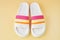 Pair of colorful multicolored rainbow flip flops or sandals on pastel background. Beach holidays and Summer concept.