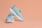 Pair of comfortable sports shoes on pale coral background. Space for text