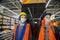 A pair of construction mannequins in protective masks against coronavirus blue cap yellow vest headphones. Construction, medicine