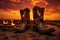 a pair of cowboy boots outlined against a fiery sunset