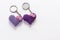 A pair of crocheted purple heart-shaped keyrings.