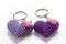 A pair of crocheted purple heart-shaped keyrings.