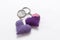 A pair of crocheted purple heart-shaped keyrings.