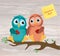 A pair of cute owlet sitting on a branch. Yellow sheet of paper