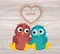 A pair of cute owls in love. Vector on wooden background. Colorful confetti in the form of heart. Greeting card or invitation for