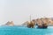 a pair of dhows - traditional arab ships - is heading to the sea from Muttrah part of Muscat dominated by a fort on a hill, Oman