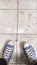 a pair of dirty looking blue shoes with a dirty floor too