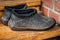 A pair of dirty old black rubber boots galoshes on the threshold of the house. Close up