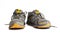 A pair of dirty old New Balance 470 v3 running trainers with holes in on a white