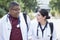 A pair of doctors, mixed race. Young people, of different sexes, in white coats, with phonendoscopes, with backpacks. walking down