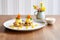 a pair of eggs benedicts on a plate with a small bowl of hollandaise