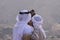 A pair of Emirati falconers hold a peregrine falcon  Falco peregrinus in the United Arab Emirates UAE a culture and tradition