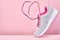 Pair of fashion stylish sneakers with flying laces, Running sports shoes on pink background