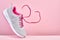 Pair of fashion stylish sneakers with flying laces, Running sports shoes on pink background