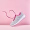 Pair of fashion stylish sneakers with flying laces, Running sports shoes on pink background