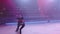 Pair of figure skaters in black stage costumes perform death spiral element,partner releases woman,they skate in