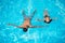 Pair floating on the surface in the swimming pool on the turquoise water at summer vacation