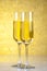 A pair of flutes of champagne on golden abstract background