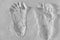 Pair of footprints cast in white textured sand