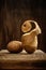 a pair of fresh raw potatoes with a cut spiral upward peel close-up on a board on an old wooden background. side view. artistic