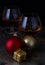 Pair of glasses of liquor on decorated Christmas table with black background