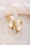 Pair of gold wedding rings on beige background