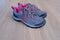 Pair of gray new womens trekking shoes with pink trim, tied with laces, concept of comfortable sports shoes for jogging and life