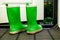 Pair of green rubber boots standing indoors near open door