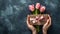 Pair of hand presenting a gift box ribbon bow with pink blooming tulips flowers leaf flora on rustic chalk table