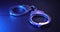 Pair of handcuffs used by law enforcement to arrest criminals, lit in red and blue flashing police lights. Justice or catching a