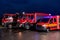 A pair of highly modern and quality fire trucks illuminate the night with their rotating lights, symbolizing the cutting