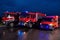 A pair of highly modern and quality fire trucks illuminate the night with their rotating lights, symbolizing the cutting