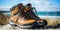 A pair of hiking boots sitting on top of a sandy beach. Generative AI image.