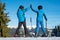 Pair holding hands standing with skis on mountain top