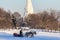 A pair of horses with sleigh ride tourists in the winter park on background of apple tree garden, front view. Winter entertainment