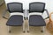 A pair of identical black office chairs placed side by side