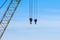 Pair of industrial crane hoists on cables near truss.