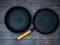 Pair of iron frying cast pans over the background of dark boards