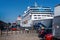 Pair of large Cruise Ships including Cunards Queen Victoria moored at Copenhagen, Denmark with hop on hop off tour bus