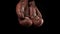 Pair of leather vintage brown boxing gloves hanging on black background