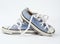 Pair of light blue worn textile sneakers with laces