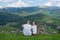 Pair of lovers sit on a hill and admire the view of the mountain